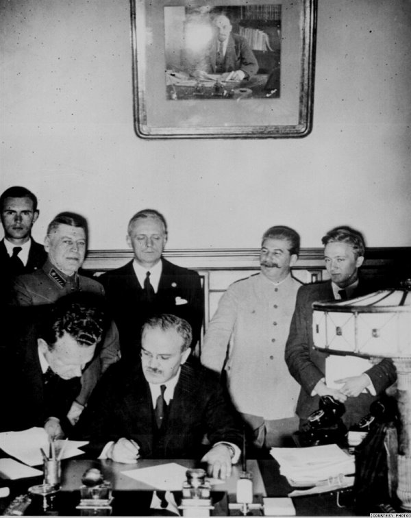 Vya&ccedil;eslav Molotov pakta imza atır. Arxada duranlar -Ribbentrop və Stalindir-Moskva, 23 avqust 1939-cu il